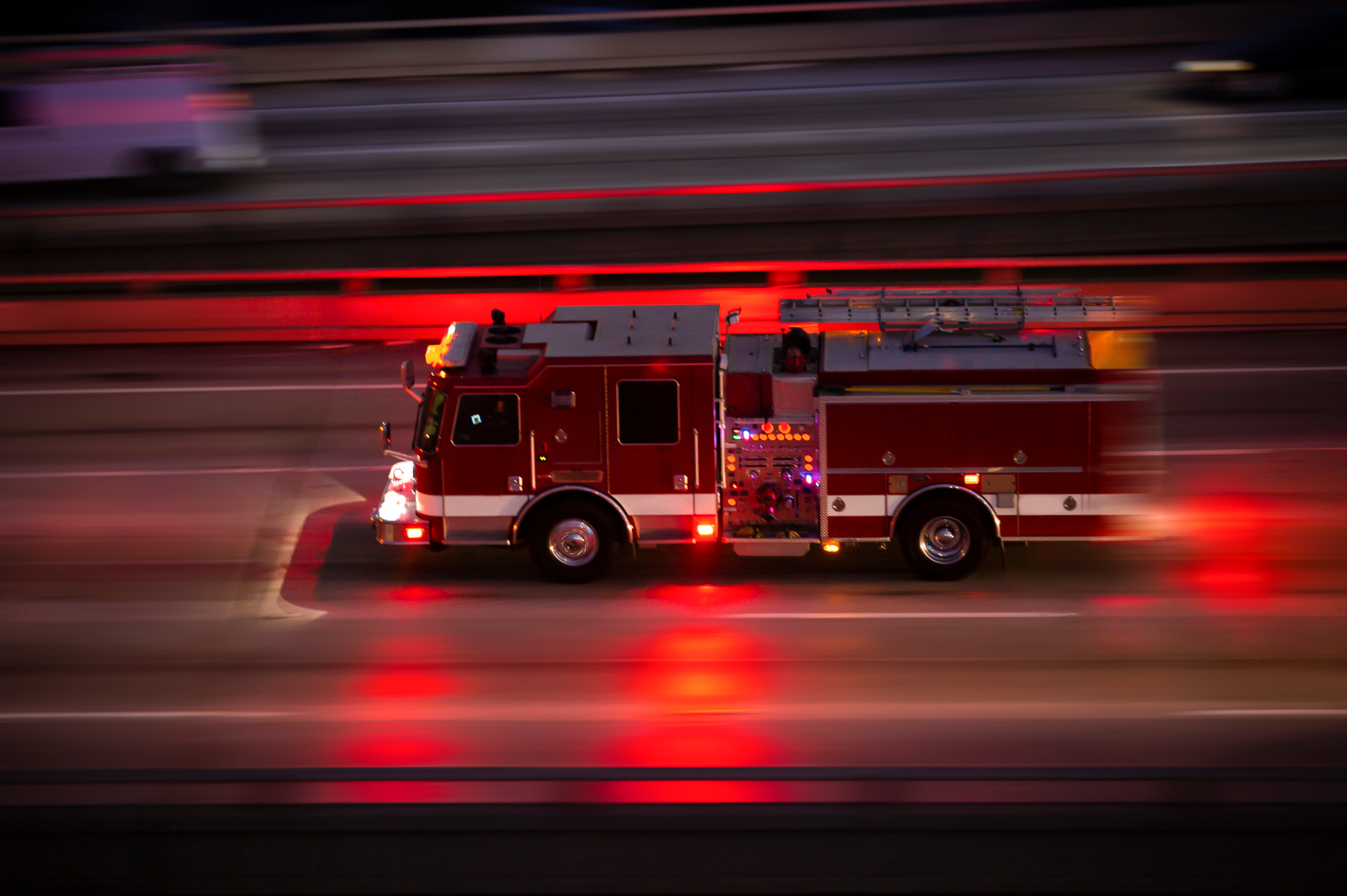 Fire engine responding at night with emergency lights flashing